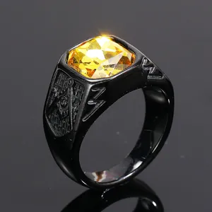 Close-up detail of black titanium steel ring with yellow gemstone and Masonic logo