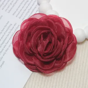 Gros plan sur une fleur de camélia en organza rouge bordeaux faite à la main de 8cm