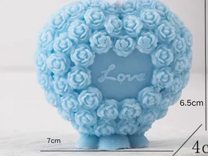 Detailed close-up of a light blue heart-shaped rose scented candle with Love carving