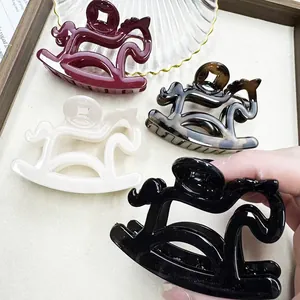 Close-up detail of rocking horse hair claw clips with coin design in various assorted colors