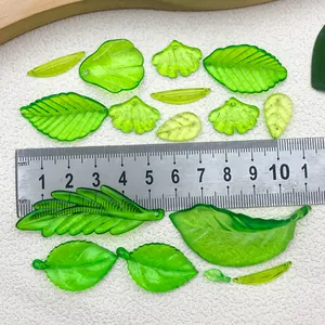 Détail macro de breloques feuilles en acrylique vert translucide pour bijoux DIY