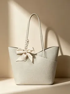 Elegant cream textured leather tote bag featuring a large silk bow and braided handle