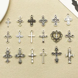 Vue détaillée de 18 pendentifs croix en argent antique disposés en grille sur un fond neutre.