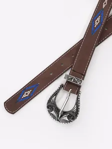 Detail of ornate silver buckle and blue diamond embroidery on a brown leather belt