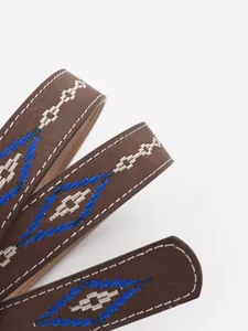 Close-up of bohemian embroidered belt with blue and white geometric diamond patterns.