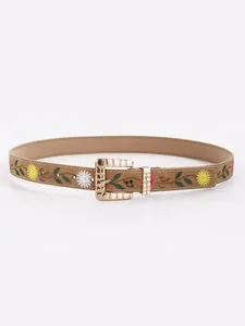 Detailed view of a vintage Bohemian faux leather belt with floral embroidery and gold buckle.