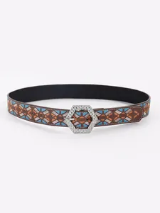 Macro view of Bohemian embroidered belt with geometric pattern and studded buckle