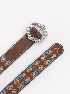 Close-up of bohemian embroidered belt with geometric patterns and hexagonal buckle.