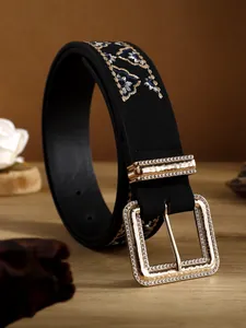 Close-up detail of vintage bohemian belt with floral embroidery and rhinestone buckle