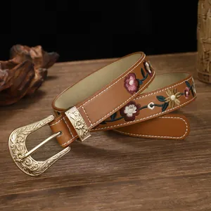 Detailed close-up of a vintage brown leather belt with colorful floral embroidery