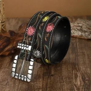 Close-up detail of Bohemian vintage embroidered leather belt with floral patterns and silver buckle