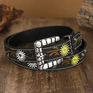 Close-up of black leather belt with vintage floral embroidery and silver buckle