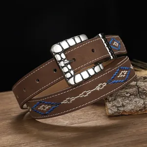 Close-up detail of bohemian embroidered leather belt featuring blue and white diamond patterns.