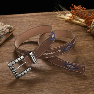 Detailed view of bohemian leather belt featuring blue and white diamond embroidery.