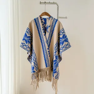 Detailansicht eines ethnischen Strickponchos mit blauen geometrischen Mustern und Fransen