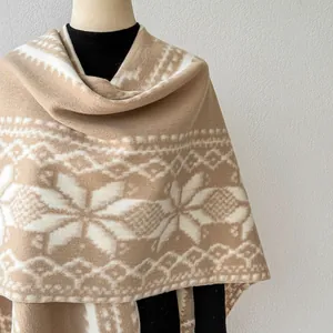 Nahaufnahme eines gestrickten Schals im Ethno-Stil mit weißem Schneeflockenmuster.