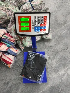 Black casual sleeveless jumpsuit in plastic packaging shown on a digital scale for weight