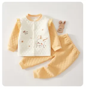 Close-up detail of quilted yellow baby thermal set with cute bunny ears and embroidery