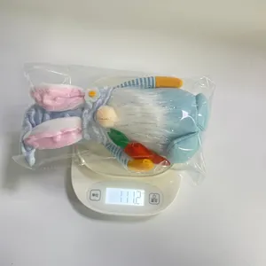 Weight measurement of cute Easter gnome plush bunny holding a carrot on digital scale
