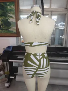 Detailansicht eines olivgrünen zweiteiligen Sportbikinis mit geometrischem Print auf einer Puppe.