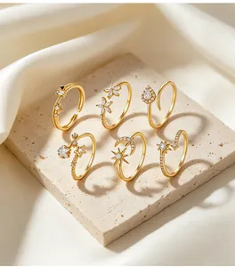 Close-up detail of elegant gold-plated rings featuring moon star and floral zirconia motifs