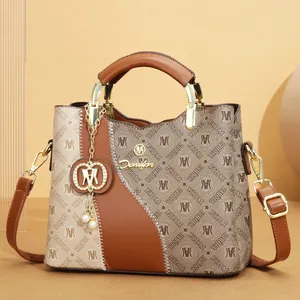 Detailed view of fashionable large capacity tote bag with brown printed pattern and gold logo