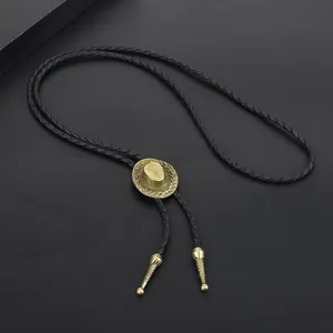 Detailed view of bronze cowboy hat bolo tie with black braided leather cord
