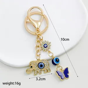Detailed product view of the gold-plated evil eye elephant keychain with size annotations