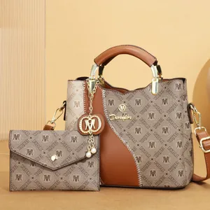 Detailed view of the printed pattern and metallic logo on the brown handbag set