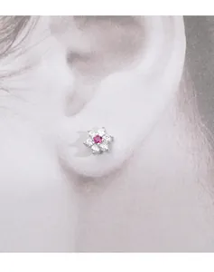 Macro detail of a delicate s925 silver flower stud earring with pink and clear crystals