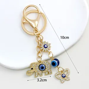 Gold-tone elephant evil eye keychain detail with 10cm length and 3.2cm width dimensions