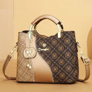 Monogram printed brown tote bag featuring golden hardware and decorative pearl charm