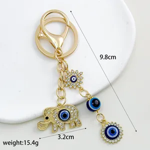 Detailed view of gold elephant keychain with blue evil eye charms including size and weight