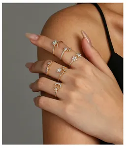 Detail view of dainty gold star and moon rings with cubic zirconia on female hand