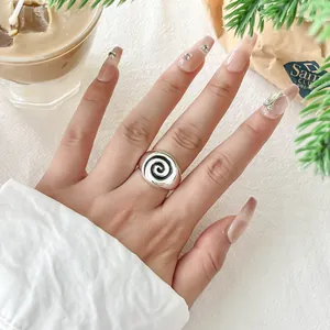 Silver finish open ring featuring a black spiral vortex design worn on manicured hand