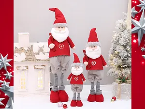Dettaglio di tre bambole telescopiche di Babbo Natale di Natale in abiti rossi a maglia.