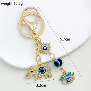 Detailed view of a gold-plated elephant and evil eye keychain showing 9.7cm length
