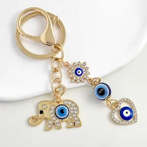 Detailed close-up of gold-plated elephant and heart evil eye keychain with rhinestones