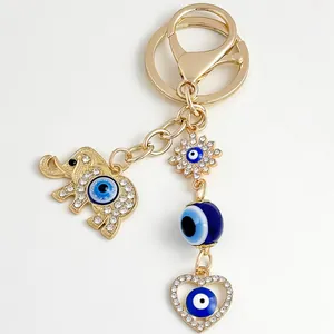 Close-up detail of golden elephant keychain with evil eye charms and rhinestones