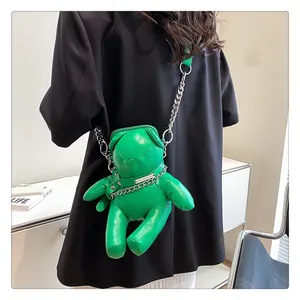 Detailansicht einer trendigen grünen Bären-Umhängetasche mit einer silbernen Kette.