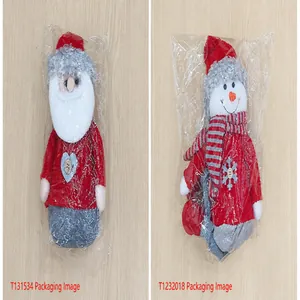 Bambole di Natale in maglia rossa e pupazzi di neve in confezioni di plastica trasparente