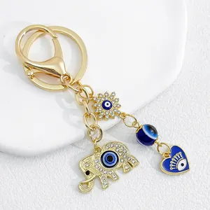 Detailed macro view of gold elephant keychain with heart charm and blue evil eye design