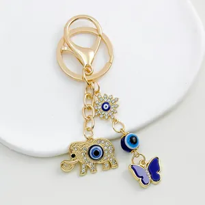 Macro view of gold elephant and butterfly charm evil eye keychain accessory detail