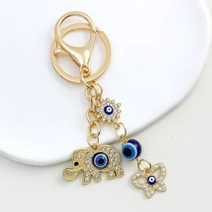 Close-up of golden elephant and evil eye charms on a sparkling rhinestone keychain