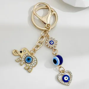 Detailed view of gold elephant and evil eye charm keychain with rhinestones