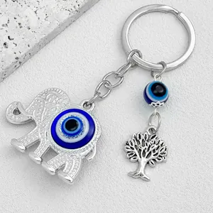 Detailed view of silver elephant keychain with blue evil eye and tree of life charms