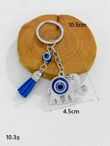 Detail view of an evil eye elephant keychain with a blue tassel and dimensions.
