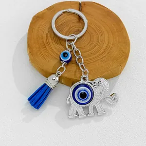 Detailed view of silver elephant evil eye keychain with vibrant blue tassel accessory