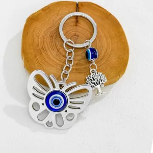 Detailed close-up of a butterfly keychain featuring blue evil eye and tree of life charms