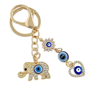 Exquisite gold elephant keychain with heart and sun charms featuring blue Evil Eye beads